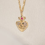 Gold pendant necklace with a heart design on a beige background