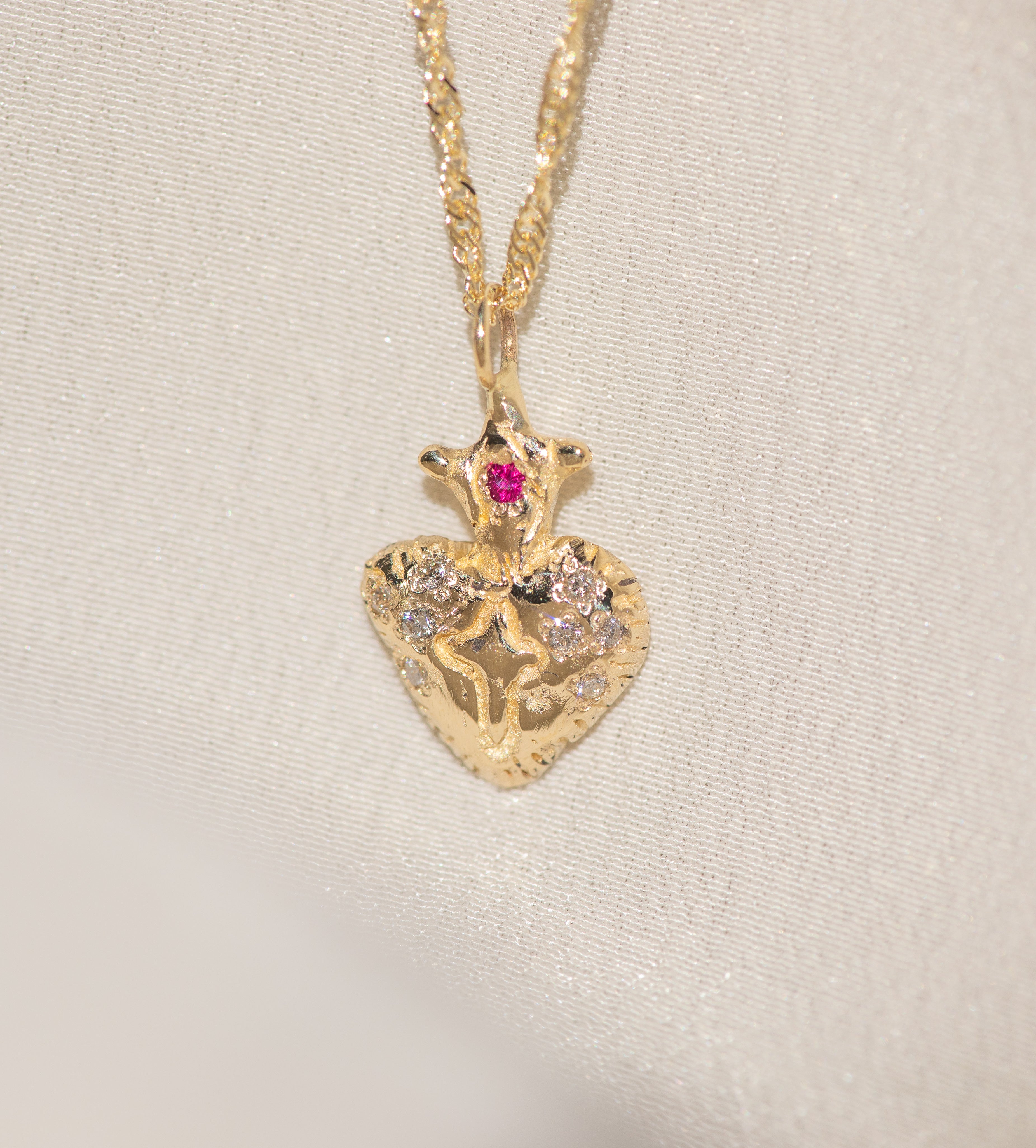 Gold pendant necklace with a heart design on a beige background