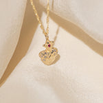 Gold necklace with a detailed pendant on a beige fabric background