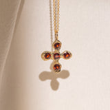 Gold necklace with a cross pendant featuring garnet gemstones