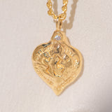 Gold heart-shaped medallion necklace featuring a white diamond and a dove