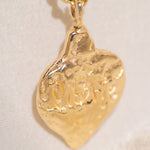 Gold pendant necklace on a light beige background