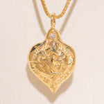 Gold heart-shaped medallion necklace featuring a white diamond and a dove